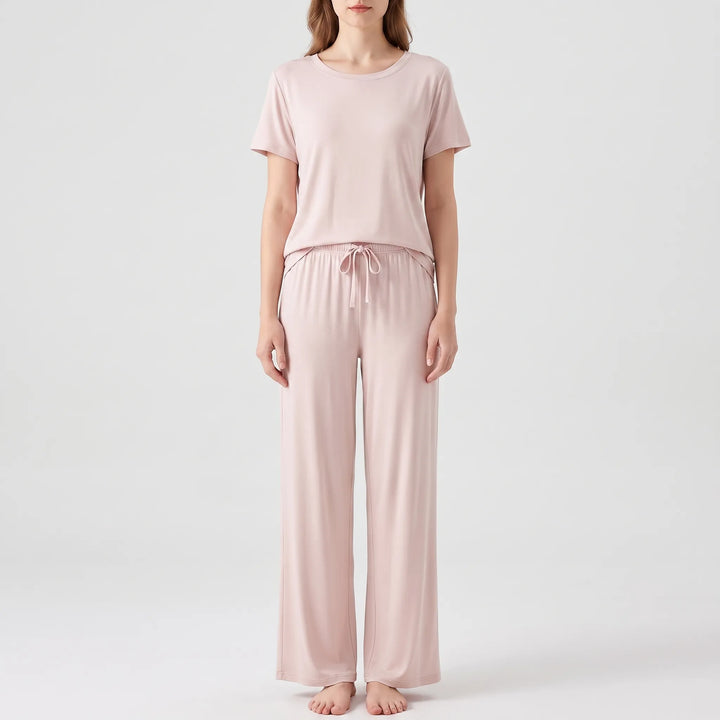 Model standing in the set in pale pink, with matching drawstring waist and wide-leg trousers, front view. 7