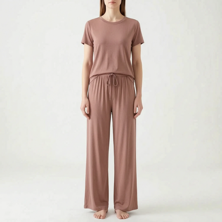 Model standing in the set in dusty rose-brown, with a crew-neck top and drawstring wide-leg trousers, front view. 9
