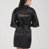 Black satin robe seen from behind on a smiling model, with gold script lettering across the upper back. 13