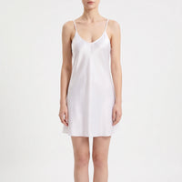Front view on a white background of the white satin slip with a V-neckline, thin straps and a loose A-line shape. 2