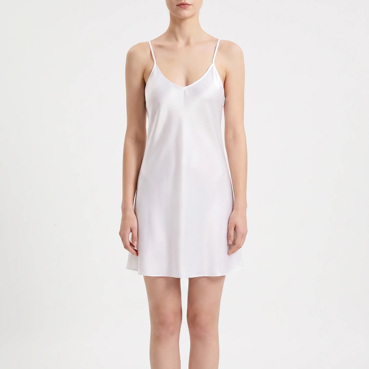Front view on a white background of the white satin slip with a V-neckline, thin straps and a loose A-line shape. 2