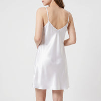 Back view of the white satin slip on a model, showing a low V-back and thin adjustable shoulder straps. 3