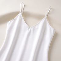 Flat lay close-up of the white slip's V-neckline and thin straps, showing the neat edge stitching. 5