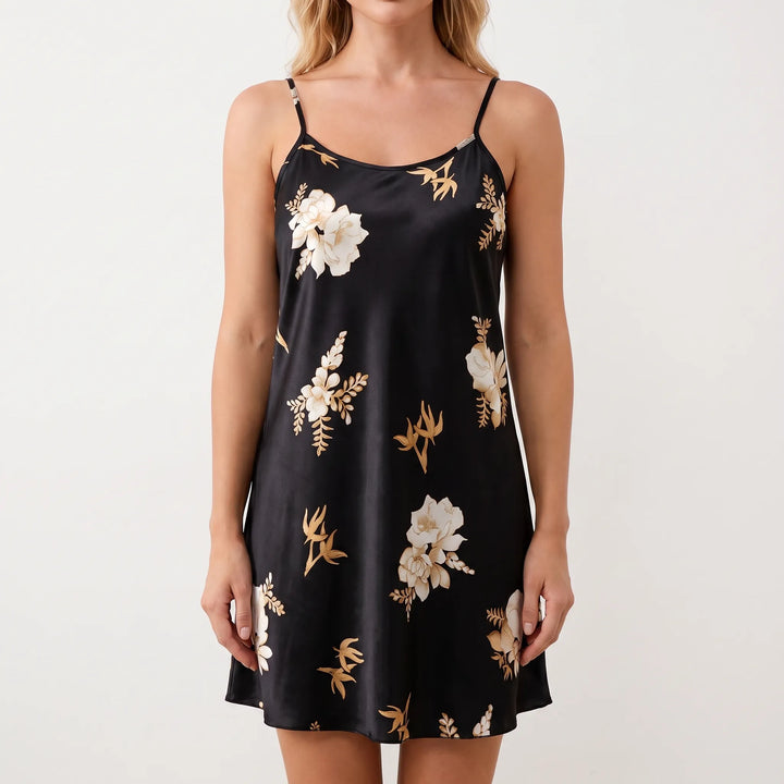 Front view of a model against a plain background wearing the black satin slip nightgown with cream and gold flowers. 2