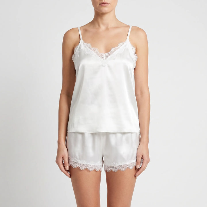 Front view on a model of the white satin cami and shorts, showing the lace-trimmed V-neckline and scalloped lace hems. 2
