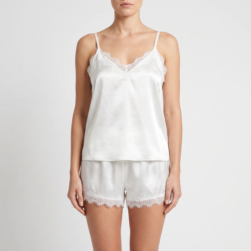 Front view on a model of the white satin cami and shorts, showing the lace-trimmed V-neckline and scalloped lace hems. 2