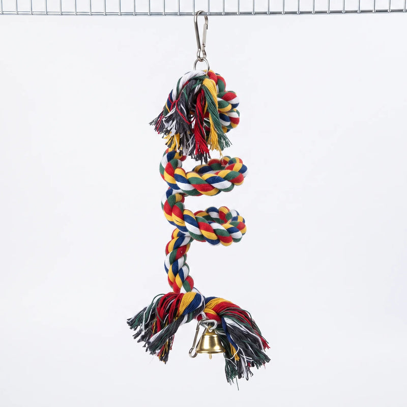 Multicoloured twisted cotton rope spiral with frayed ends, a gold bell and a metal clip, hanging from a wire cage roof against white. 1