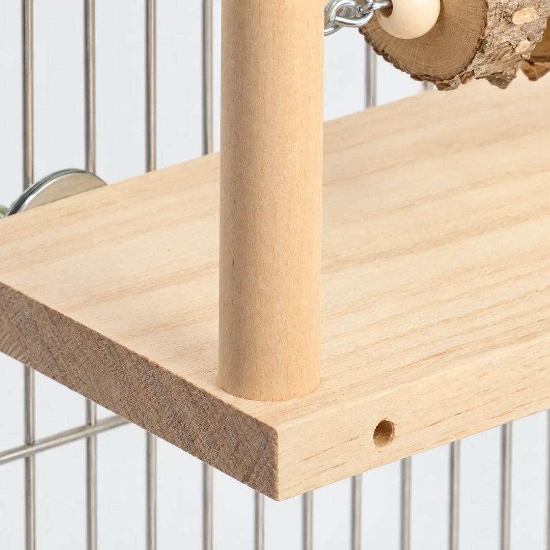 Close-up of one wooden post fixed into the platform, showing the pale wood grain, a small drilled hole and a metal disc against the cage bars. 3