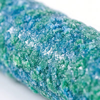 Close-up of the perch's coarse, sandy surface, mottled in blue and green, showing the rough grain birds grip. 4