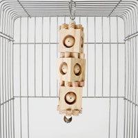 Close view of the natural wooden toy hanging from a screw-gate clip, showing three blocks with ball-filled holes and the bell. 4