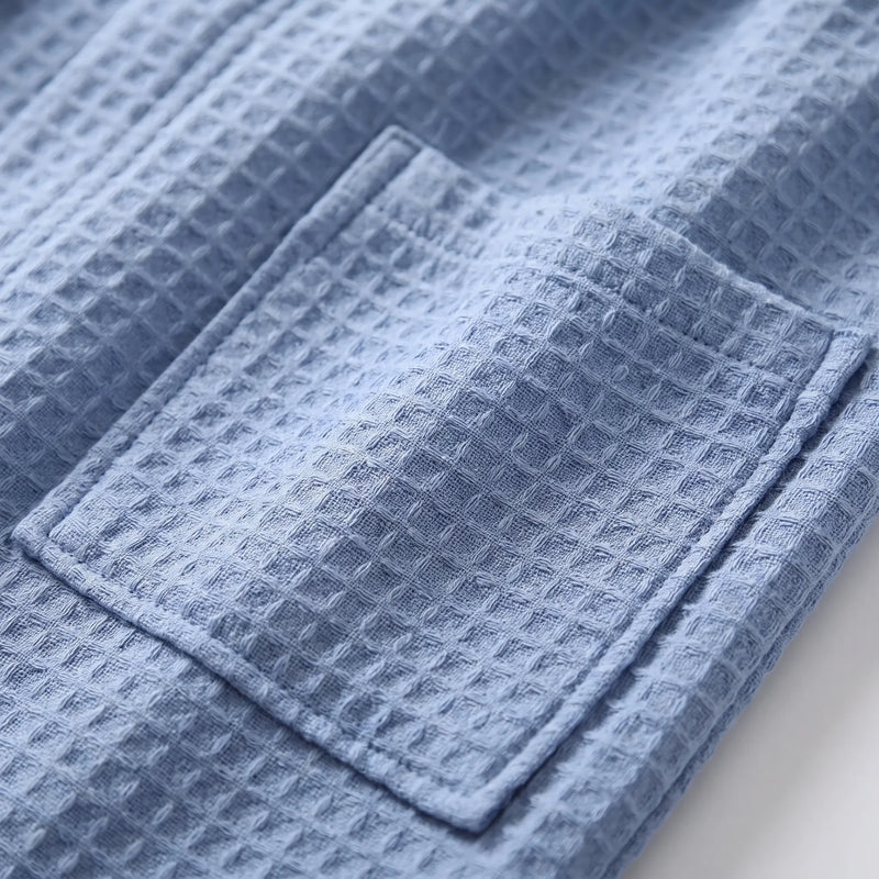 Close-up of the blue waffle-weave fabric and a stitched patch pocket, showing the raised grid texture. 5