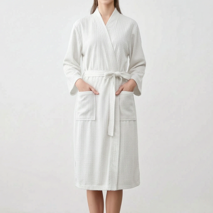 Model wearing the robe in white, hands in the patch pockets, belt tied in a bow at the waist. 7
