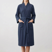 Model wearing the robe in dark navy, hands in the patch pockets, belt tied in a bow at the waist. 8