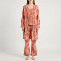 Front view of the set in a coral orange colourway with brown palm-leaf print, worn by a model. 9