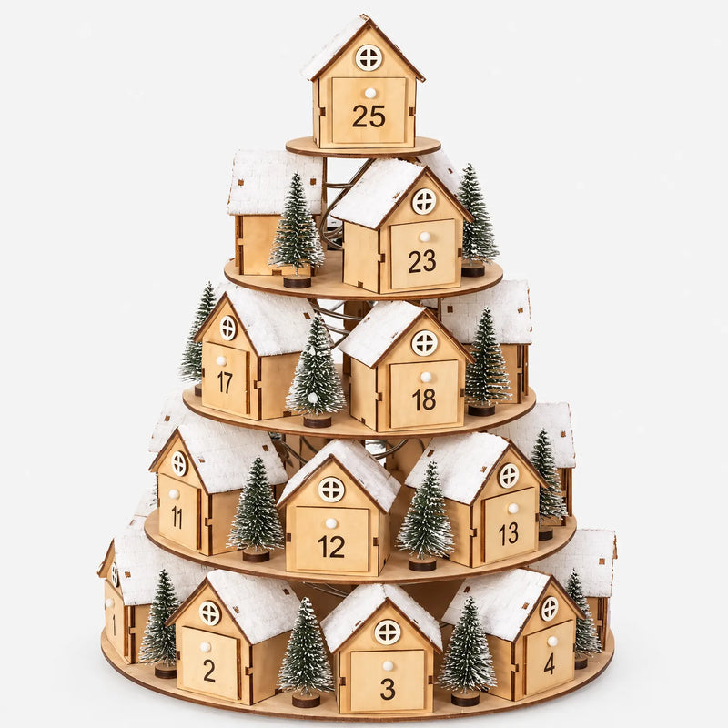 Tiered wooden village advent calendar with numbered drawer doors, snowy roofs and small fir trees, shown against a plain white background. 2