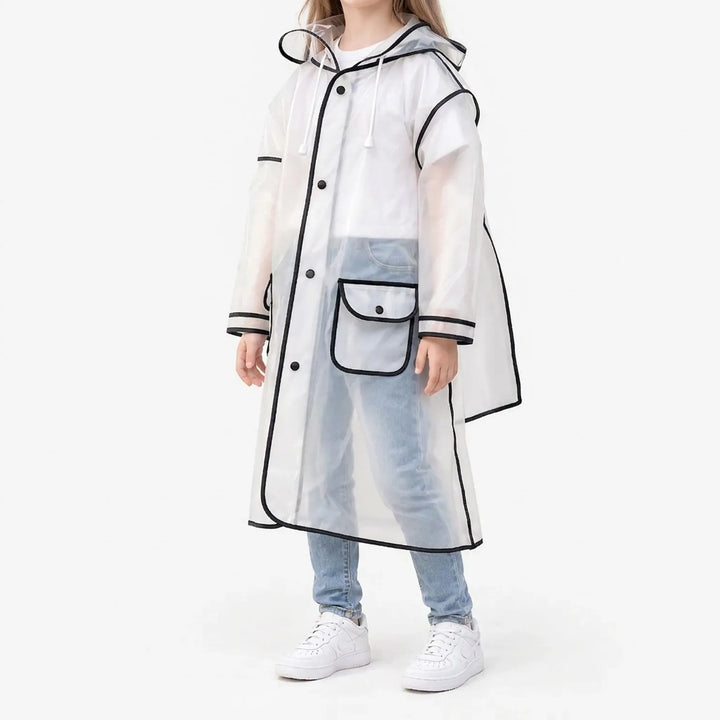 Side view of a girl in the frosted clear raincoat with black trim, snap buttons, a flap pocket and drawstring hood, with white sneakers. 2