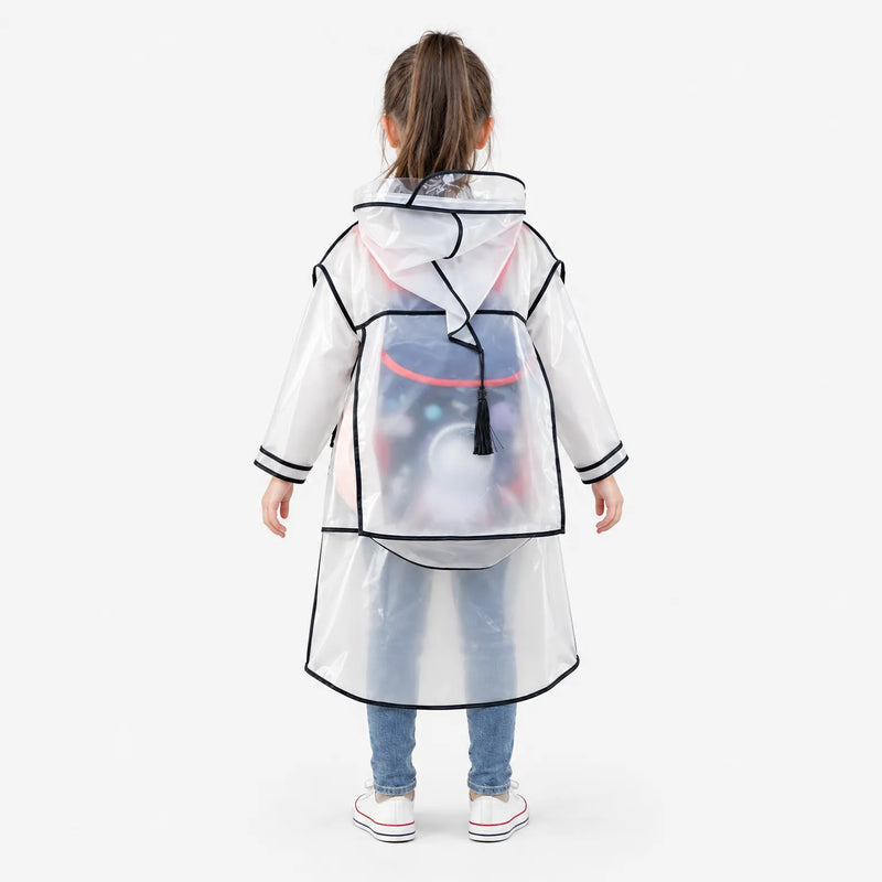 Back view of the clear raincoat with black trim, showing a roomy backpack cover panel over a child's schoolbag and a black tassel on the hood. 4