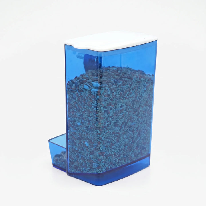 Blue translucent seed feeder with a white lid, filled with seed and showing the small feeding tray at the front. 1