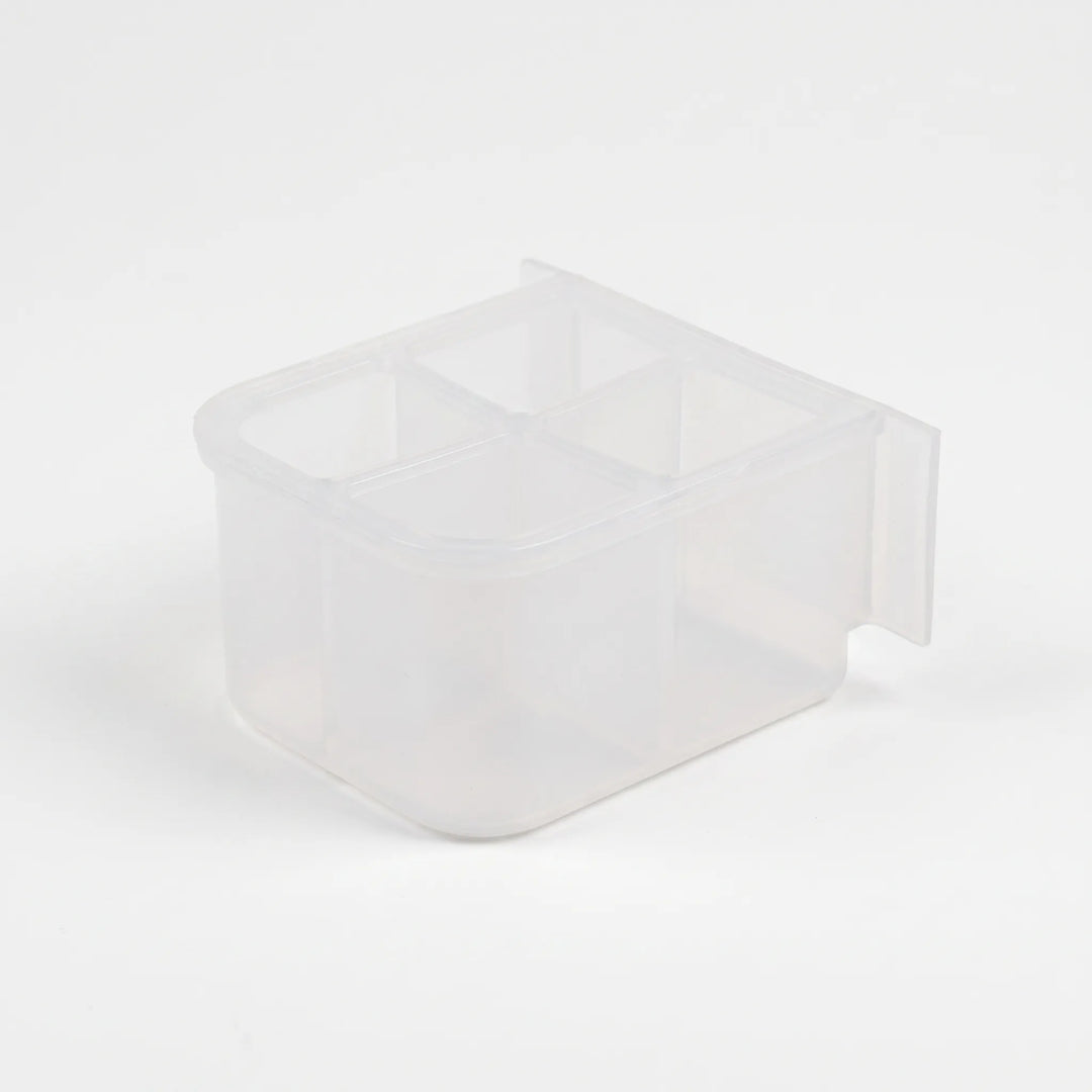 Empty small clear plastic feeder with four compartments, seen from above at an angle with a flat mounting tab at the back. 5