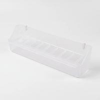 Angled view of the empty long clear feeder showing its row of small compartments and two hanging pegs. 7