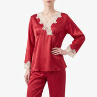 Close front view of the red satin pyjama top on a model, showing the V-neck cream lace trim and lace cuffs. 2