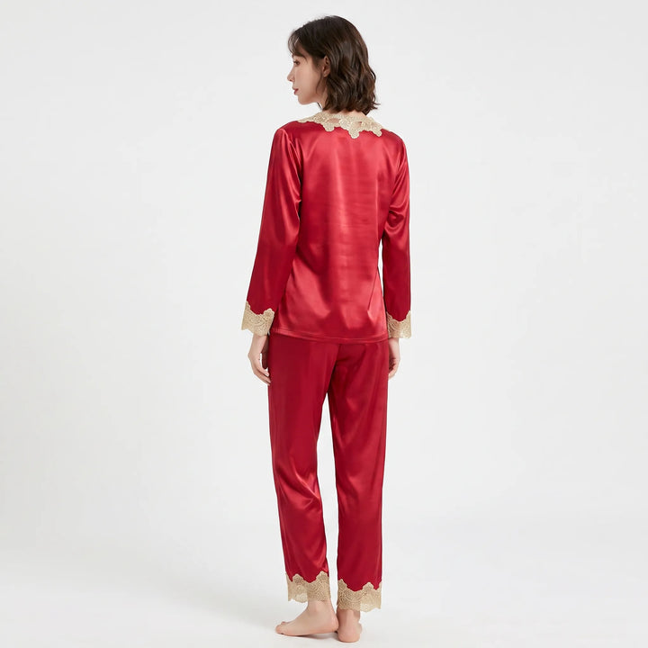 Back view of a model in the red satin pyjamas, showing lace at the nape, sleeve cuffs and trouser hems. 3