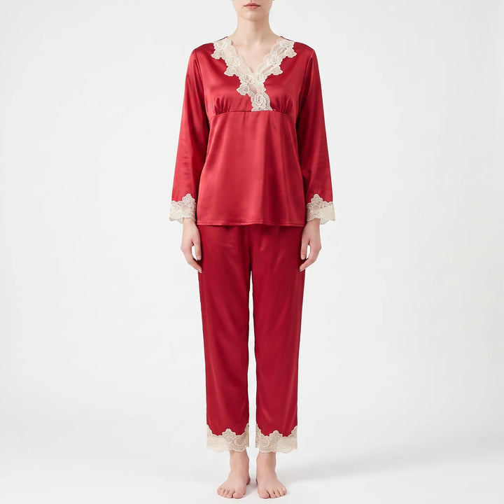 Full-length front view of a model standing barefoot in the red satin pyjama set with lace-trimmed cuffs and trouser hems. 6