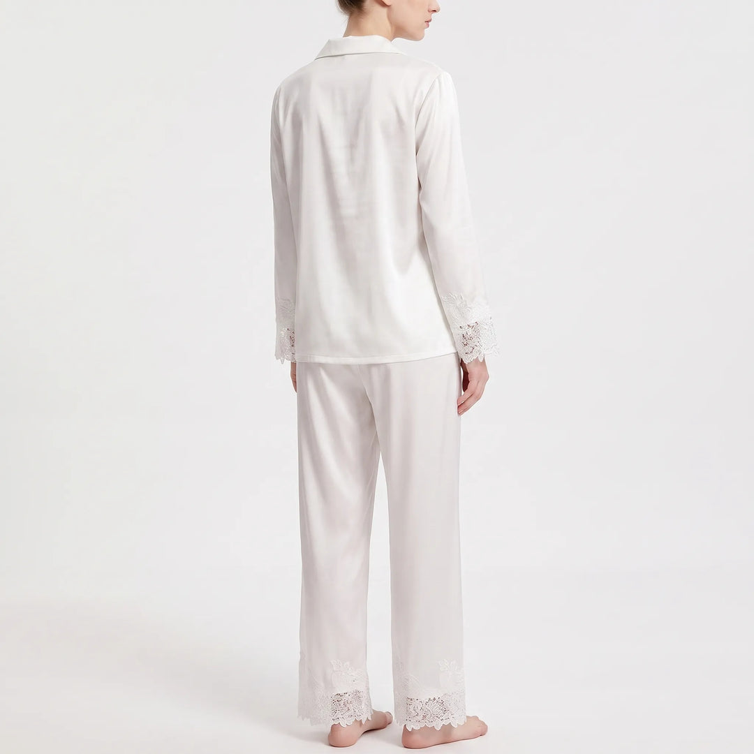 Back view of the white satin pajama set, showing the plain back of the shirt and lace trim on sleeves and trouser hems. 3