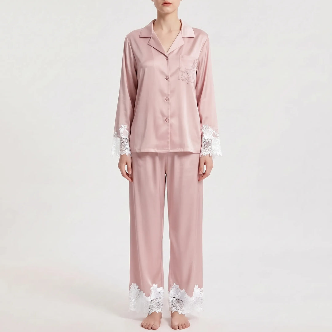 Front view of the pajama set in dusty pink satin with contrasting white floral lace on the sleeve cuffs, pocket and trouser hems. 7