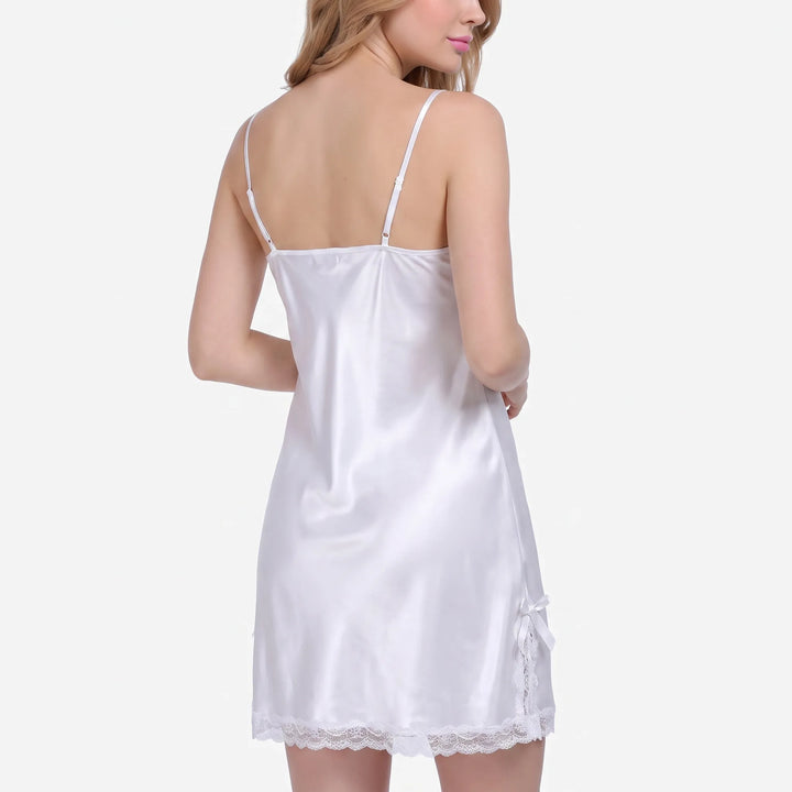 Back view of the white satin nightdress on a model, showing adjustable thin straps and a bow with lace at the hem side. 3