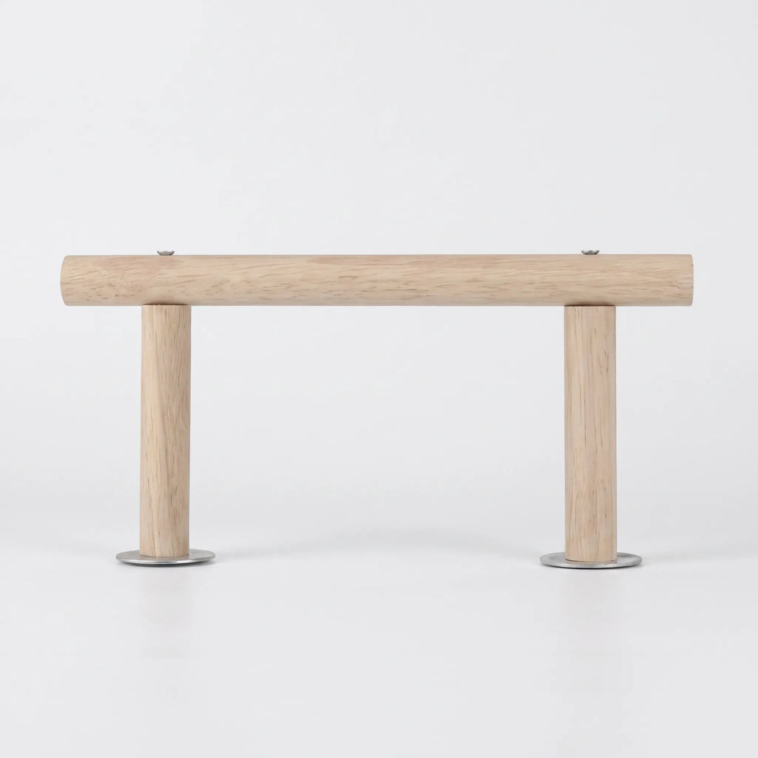 Side view of the wooden perch on a plain white background, a long horizontal rod held up by two short legs with metal washers. 1