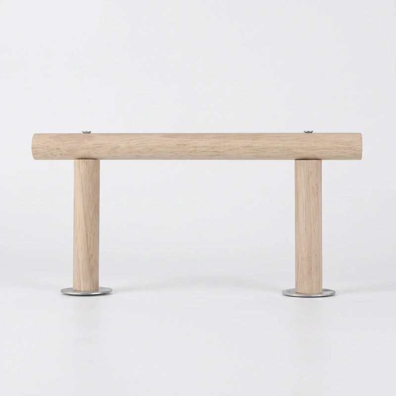 Side view of the wooden perch on a plain white background, a long horizontal rod held up by two short legs with metal washers. 1