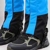 Close-up of the lower part of bright blue and black gaiters, showing the zip, stitching, boot lace hook and underfoot strap buckle. 5