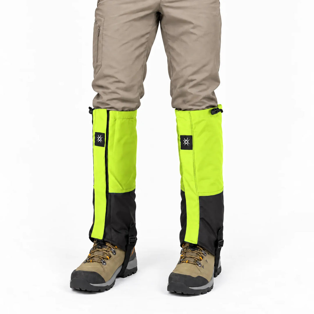Front view of lime green and black gaiters worn over beige trousers and hiking boots, with drawcord tops and ankle straps. 6