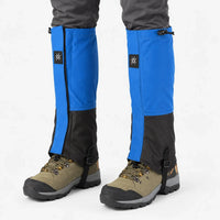 Blue and black gaiters worn with grey trousers and olive hiking boots, showing the zipped front, drawcord tops and underfoot straps. 7