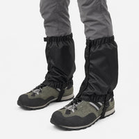 Black ripstop gaiters with zip closure and elastic hems, worn over green hiking shoes against a white background. 5