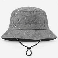 Front view of a grey bucket hat with adjustable black-and-white drawcord, water droplets beading on the fabric. 2