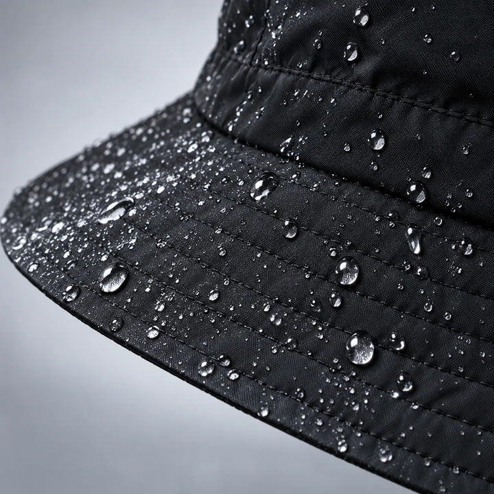 Close-up of a black hat brim and crown, water droplets beading on the stitched fabric. 6