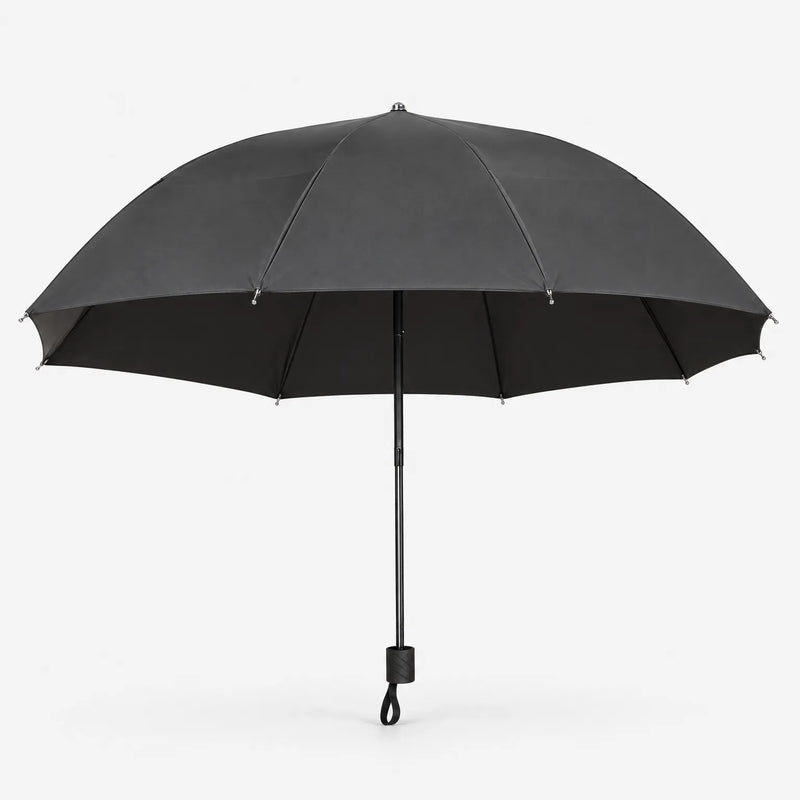 Open dark grey umbrella seen from the side on white, showing its wide canopy, black lining and handle with wrist loop. 3