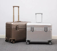 Gold-toned and silver ribbed suitcases standing side by side with telescopic handles raised against a pale wall 7