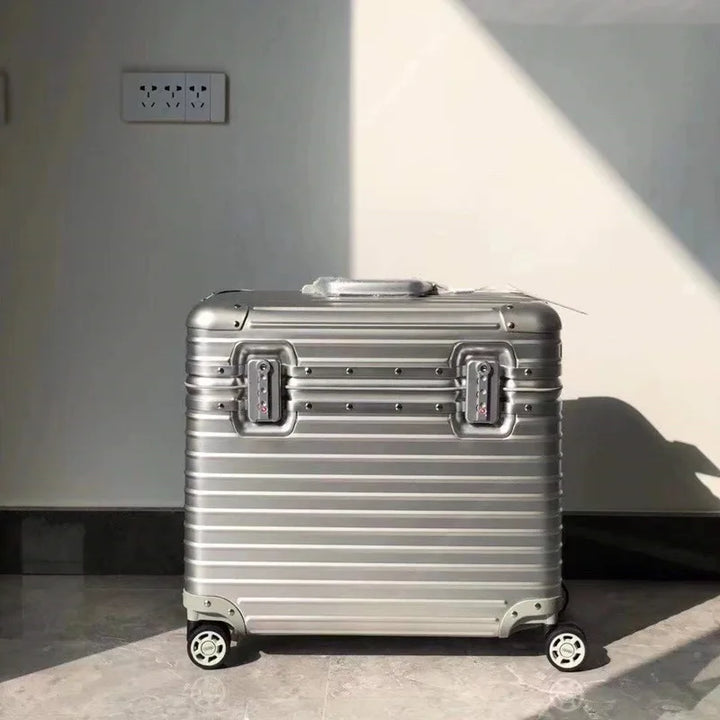Front view of a silver ribbed case with two combination locks and a top handle, standing in a bright room 8