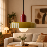 Glossy olive disc pendant with red cap and glowing bulb in a cosy living room 59
