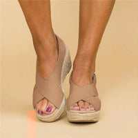 Front view of tan crossover-strap wedges worn with feet side by side, showing the open toe and woven sole 10