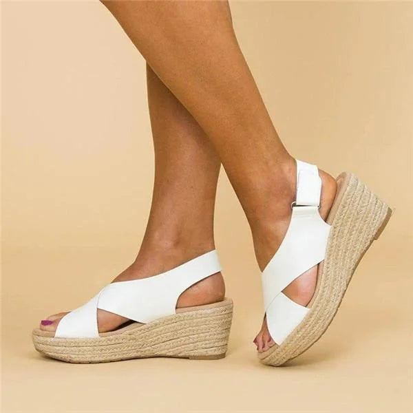 White criss-cross wedge sandals with jute platform and adjustable heel strap, worn by a model in side view 5