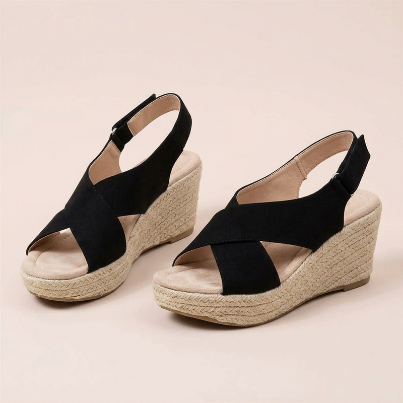 Pair of black crossover wedge sandals with cushioned footbed, braided jute wedge and hook-and-loop heel straps 12
