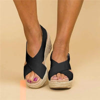 Close front view of black crossover wedges worn by a model, standing with feet together 9