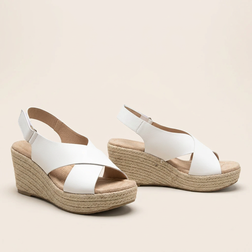 Pair of white crossover wedge sandals with padded footbeds and braided jute wedges against a cream background 15
