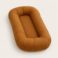 Empty caramel-brown support pillow with raised, rounded sides, shown at an angle on a plain background 9