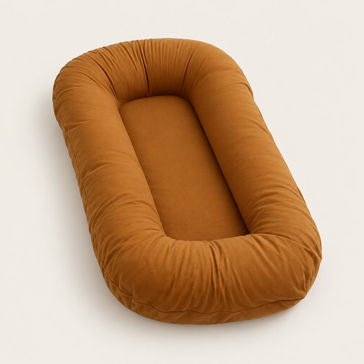 Empty caramel-brown support pillow with raised, rounded sides, shown at an angle on a plain background 9