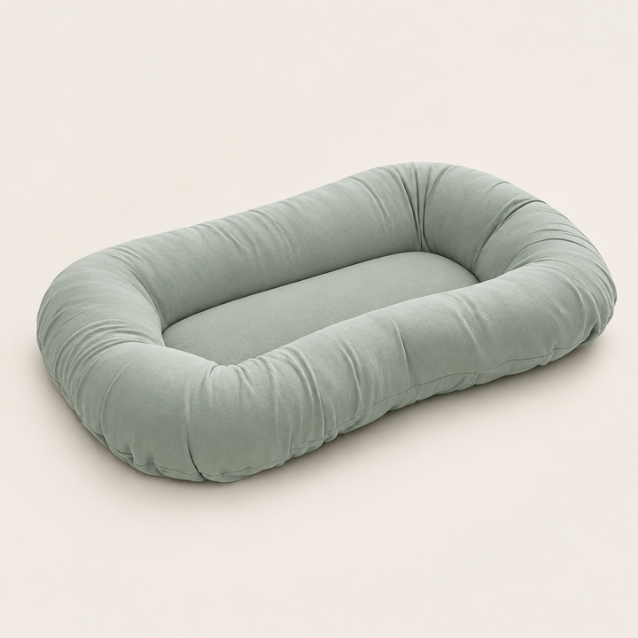 Empty sage green support pillow with raised sides, shown at an angle on a plain background 8